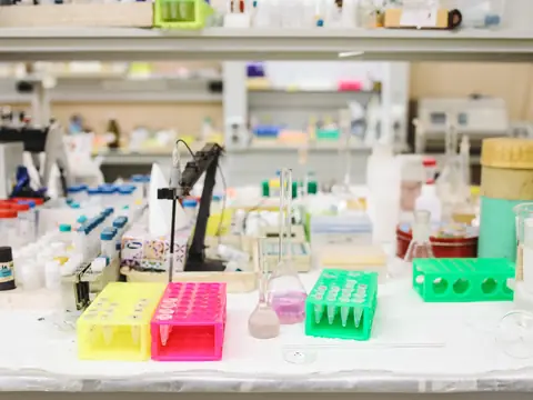 A laboratory bench with sample racks, bottles and flasks