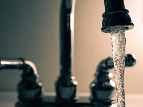 Water running from a black kitchen faucet