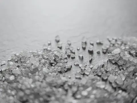 Coarse salt crystals on a gray surface