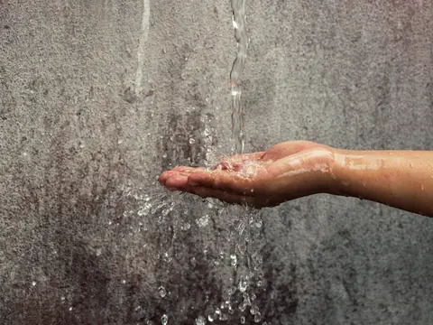 A hand held under a falling stream of water