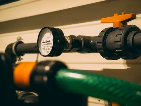 A pressure gauge and a valve on a water line