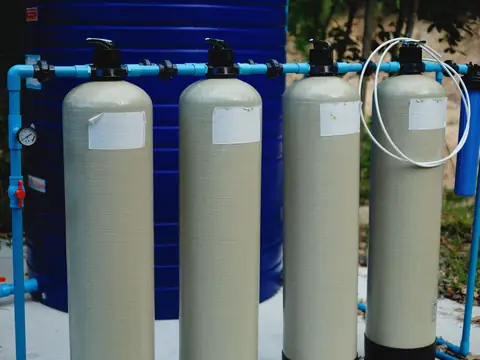 Four tall filter tanks connected by blue pipes